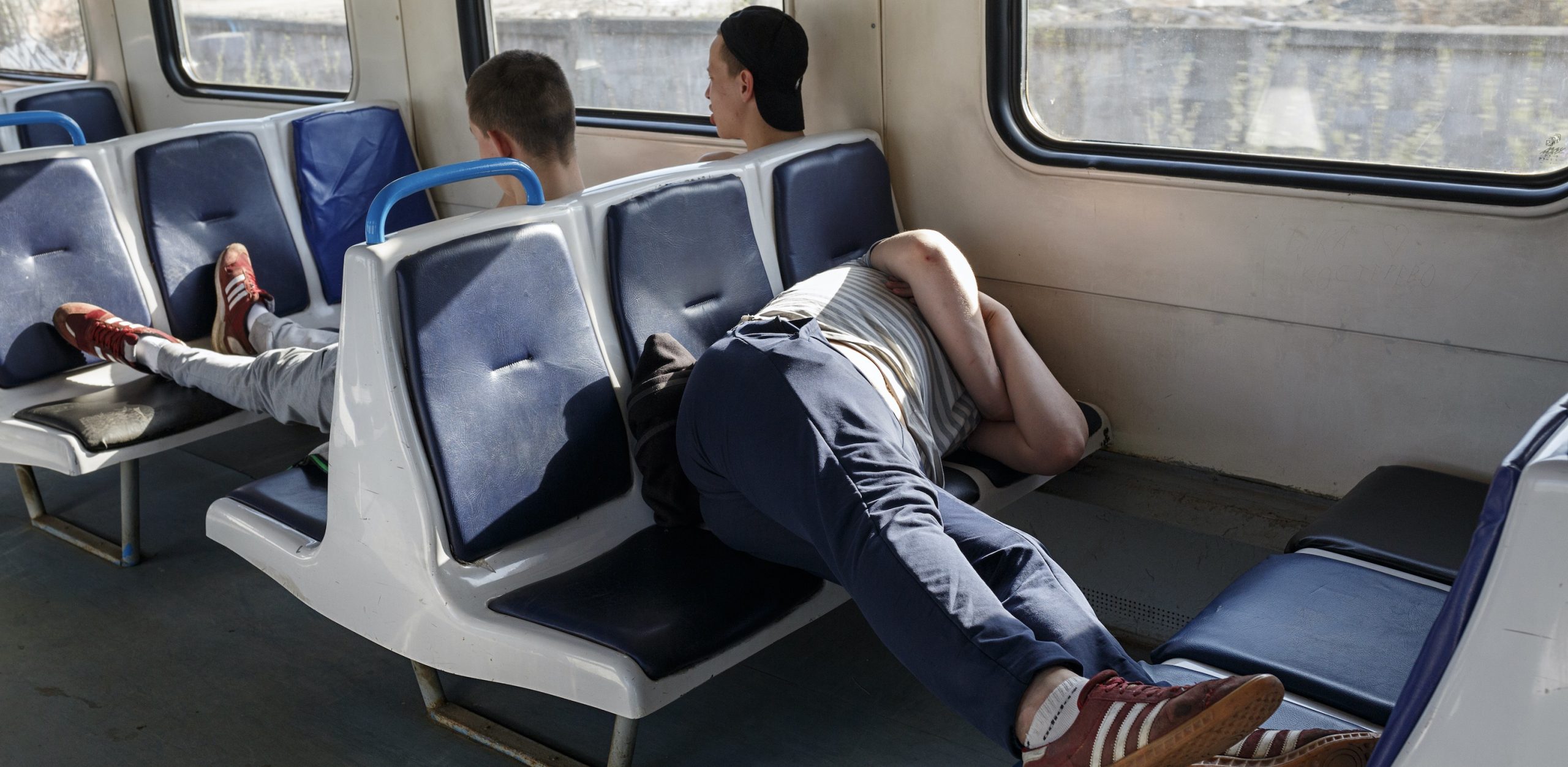 Поезд устал. Ноги в транспорте. Спящий человек в электричке. Человек сидит в электричке.